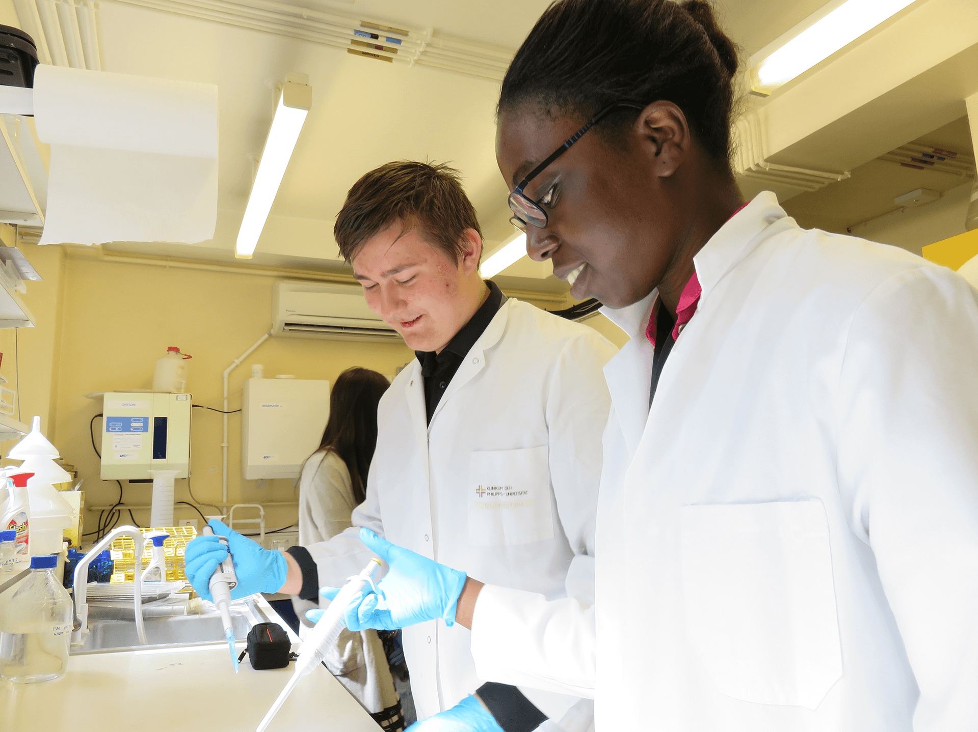 In2Research students with lab coats and pipettes