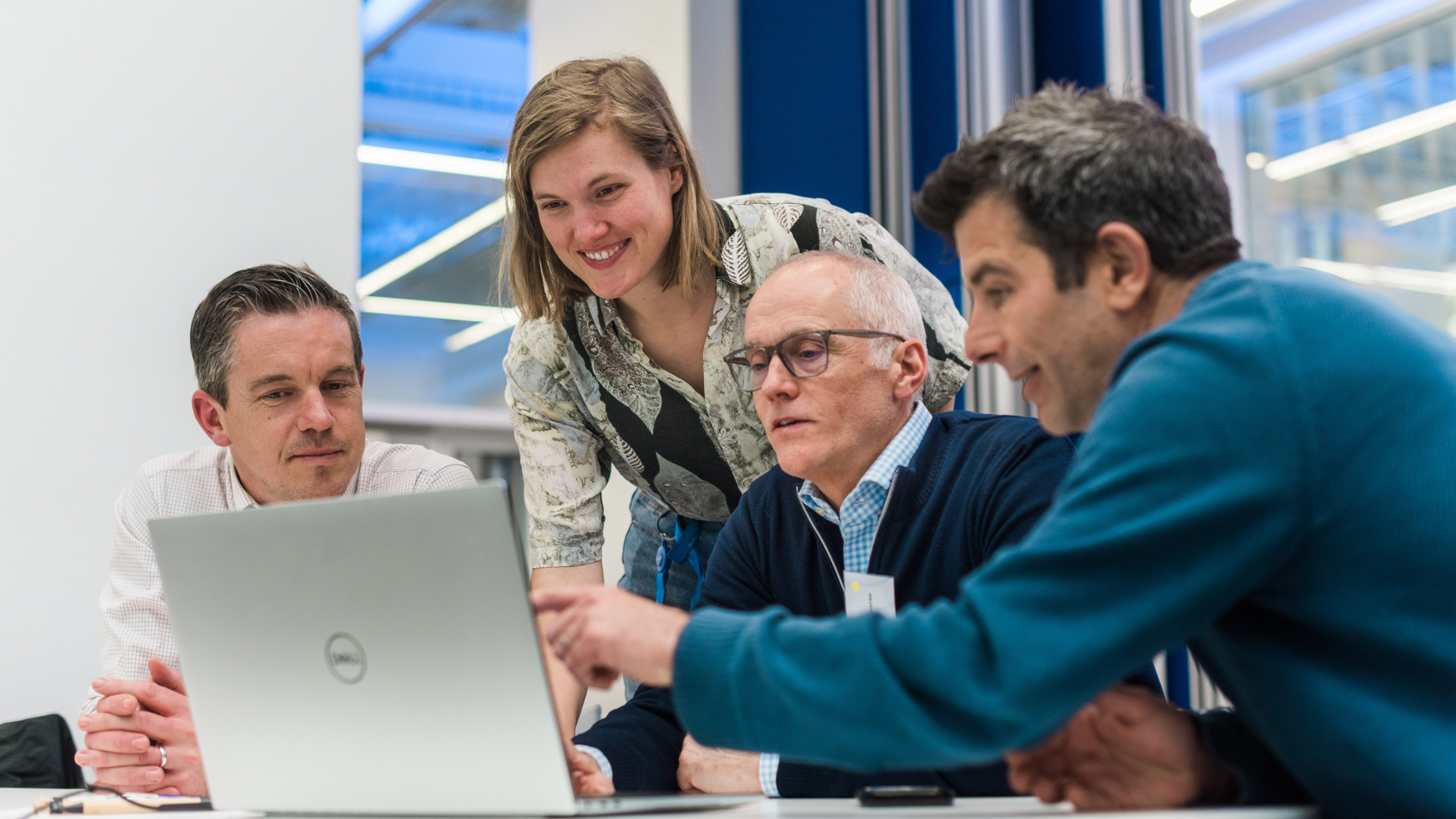 Teachers and students gathered around laptop
