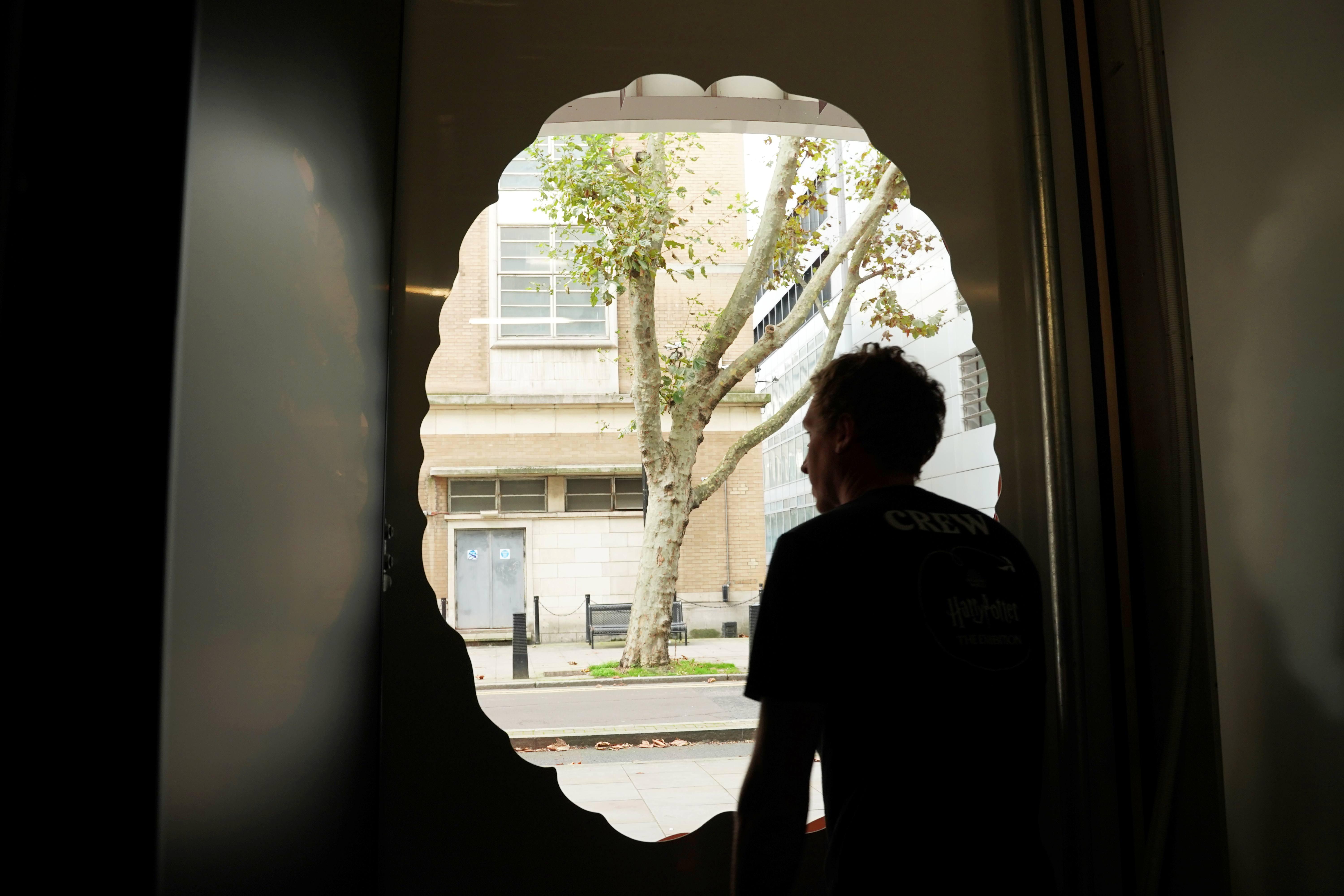 Photo of a person looking out through a cut out of a brain during the vitrine installation at SWC