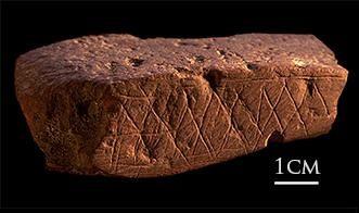 Ochre stone found at the Blombos cave site. The pattern dates from approximately 70,000 years ago.