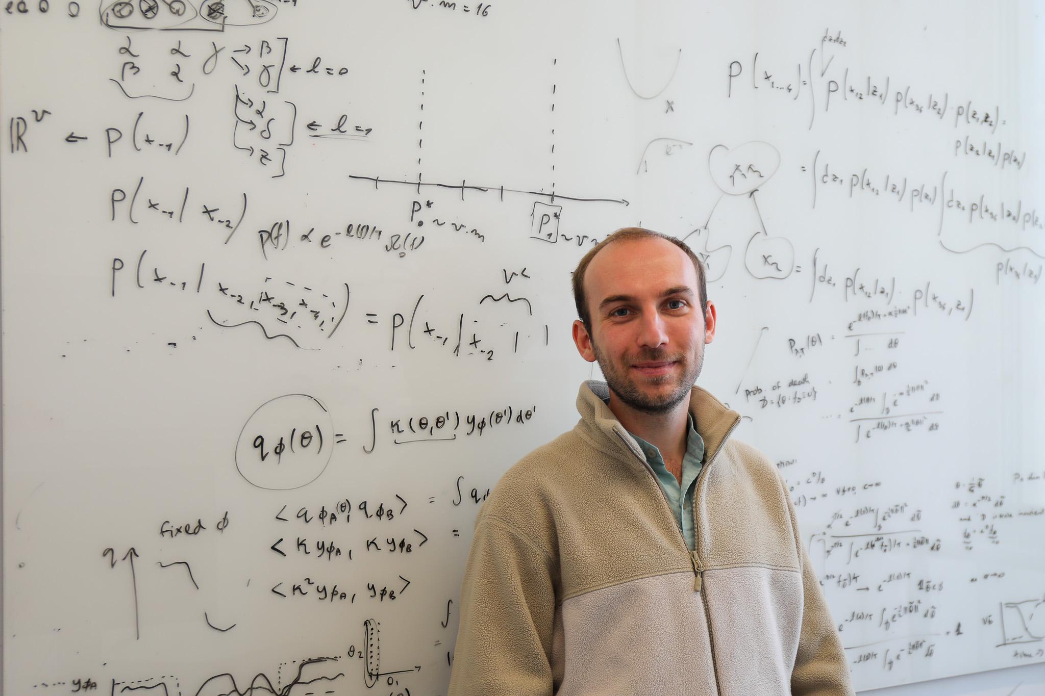 Photo of Sam Leibana in front of a whiteboard with mathmatical equations