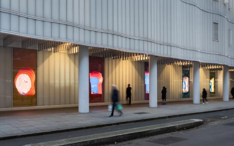 Photo of the five window displays outside the SWC building on Howland Street with people passing by