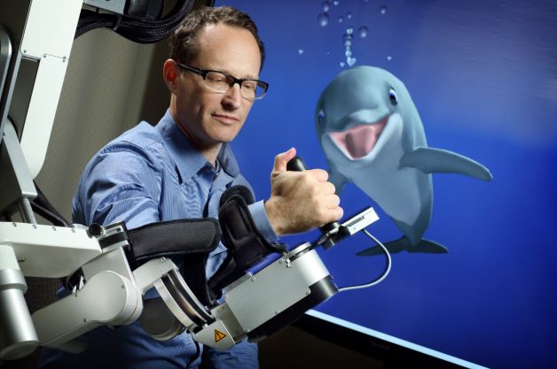 Dr John Krakauer with a dolphin behind him 