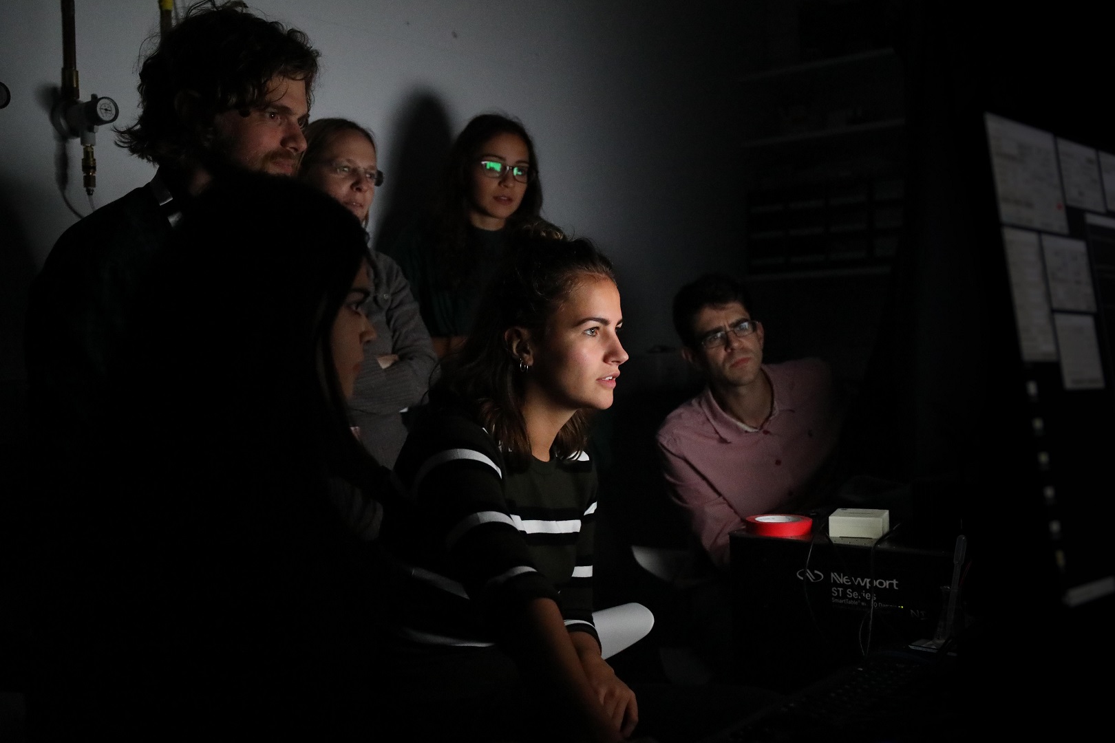 Photo of SWC PhD students, post-docs, and faculty observing an experiment
