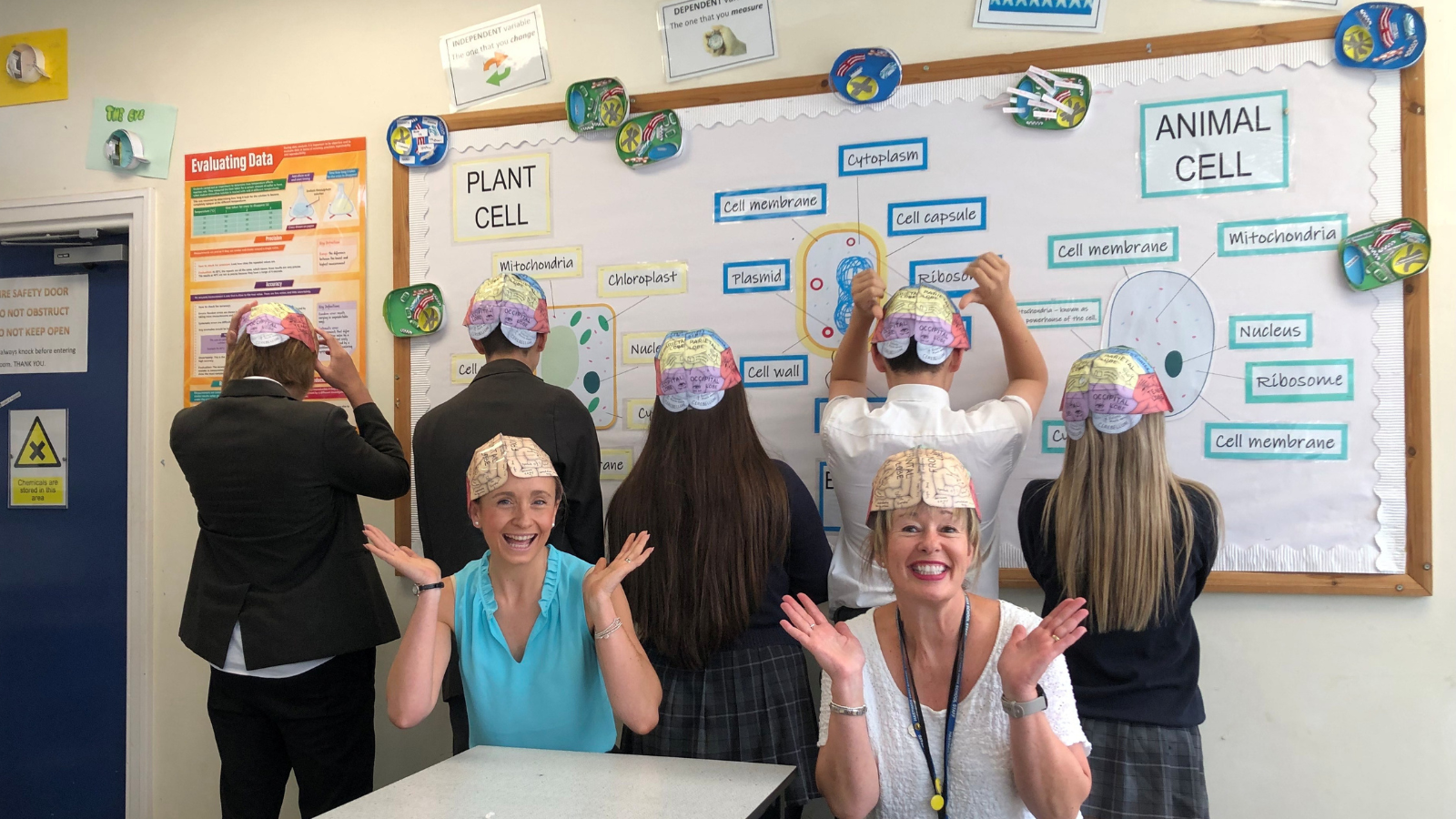 Photo of students and teachers wearing brain hats in their science classroom
